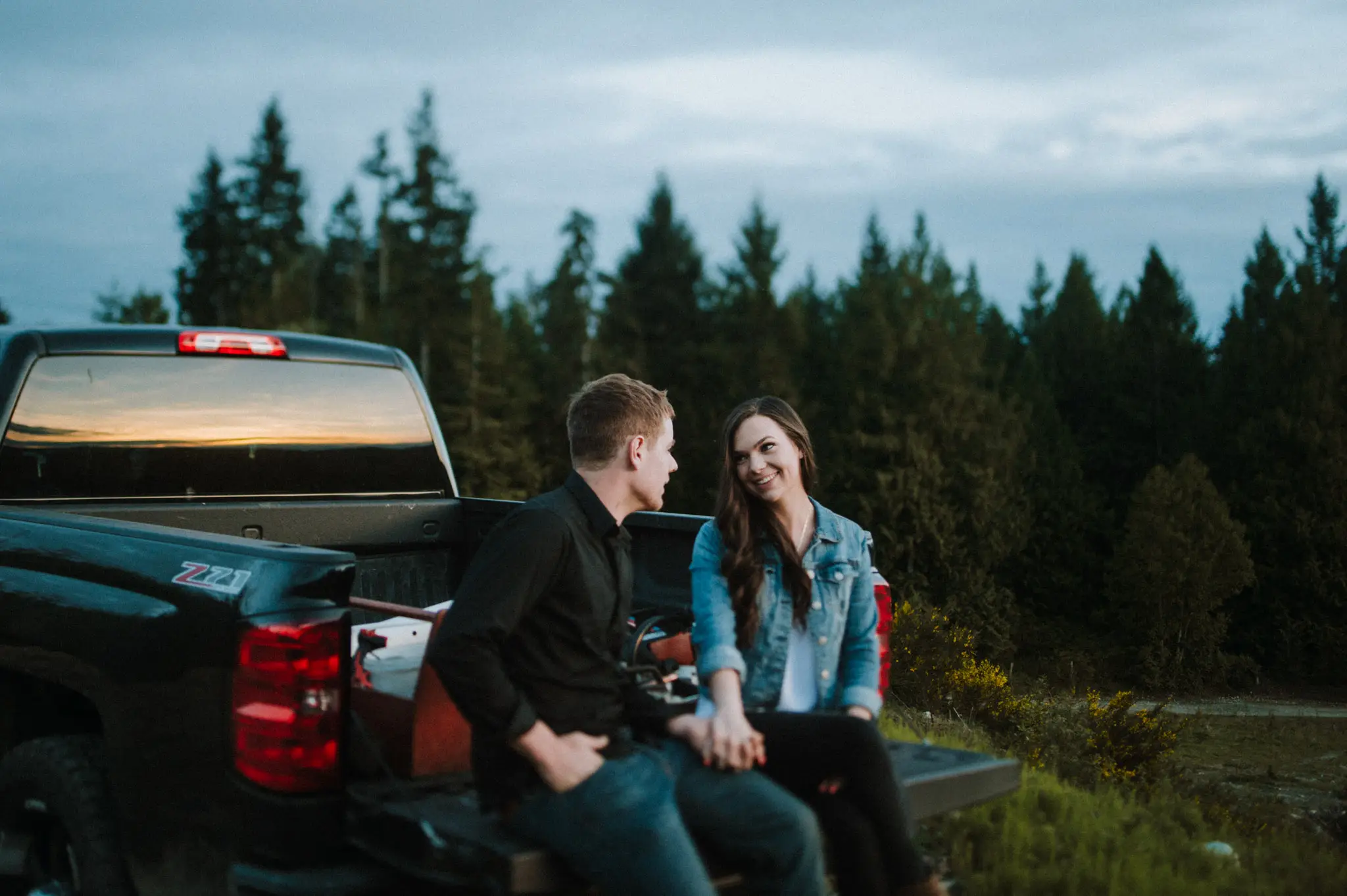 young couple sitting on tailgate at sunset mini session Sunshine Coast BC