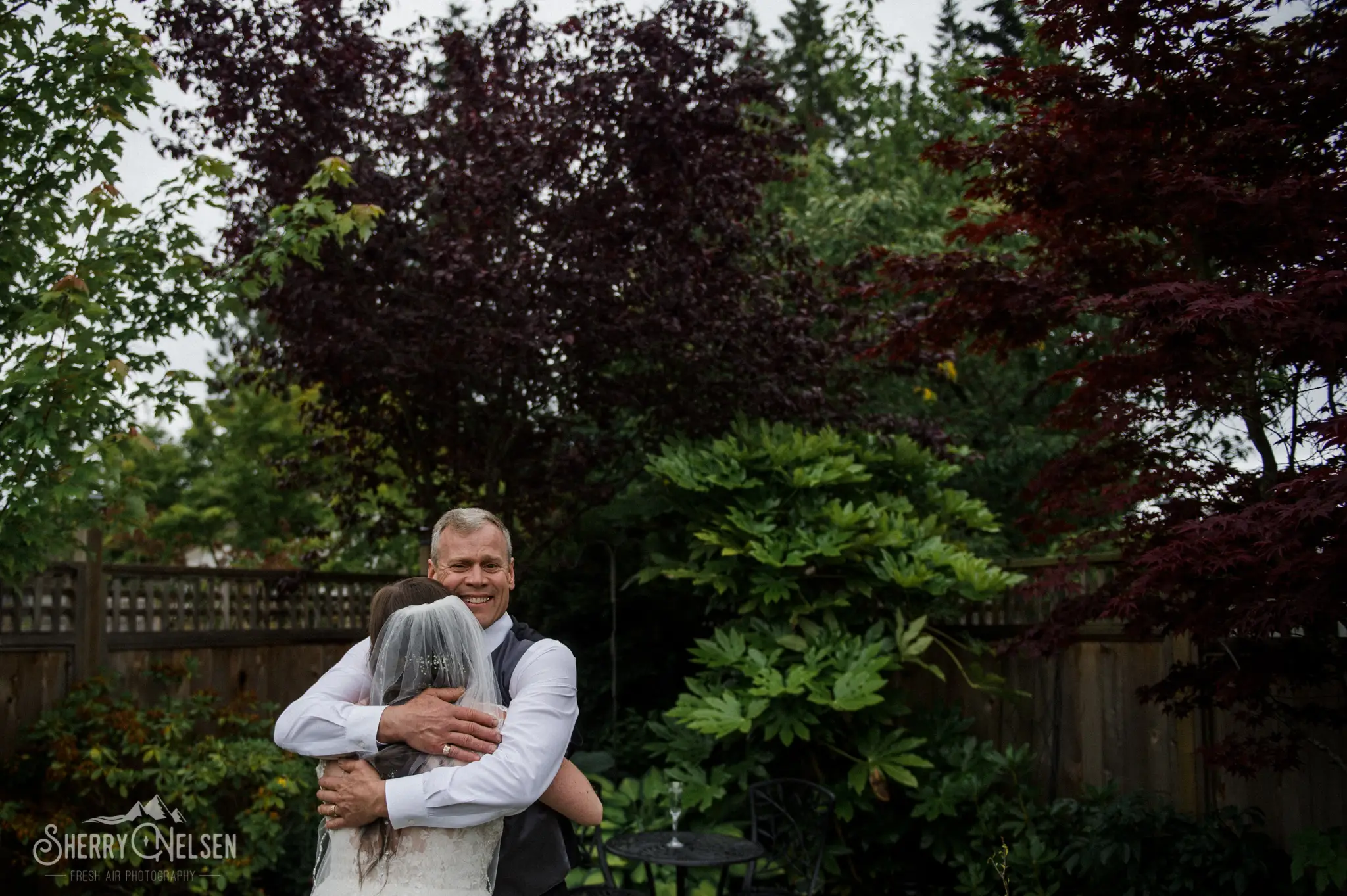 Dad sees his daughter as a bride before she marries and gives her a big hug