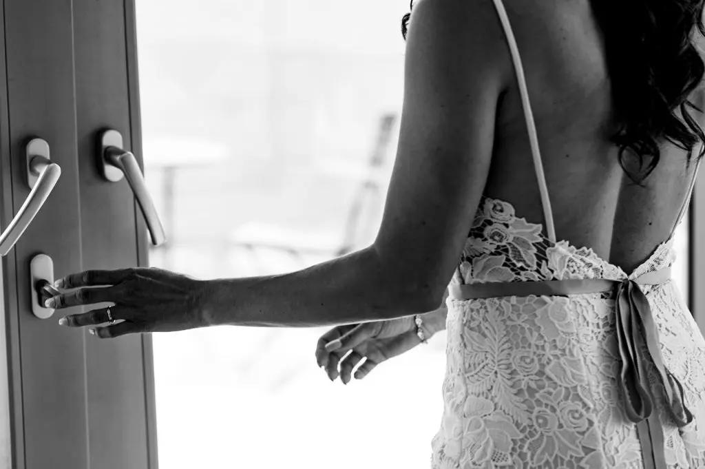 bride opens door to patio