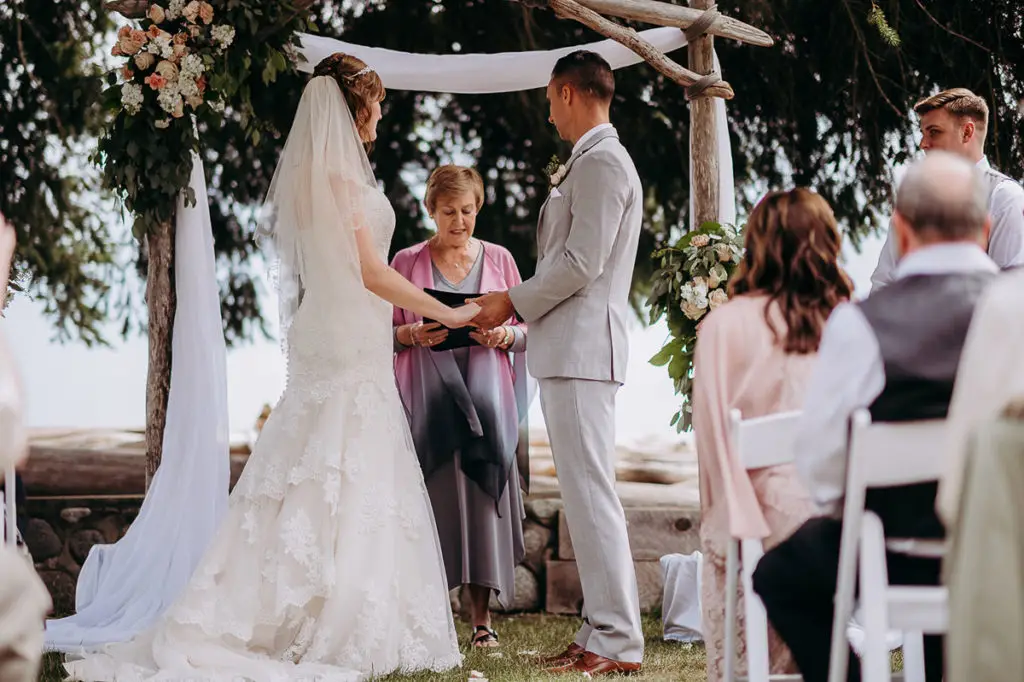 couple listening to words spoken by the BC comissioner at their Gibsons BC wedding