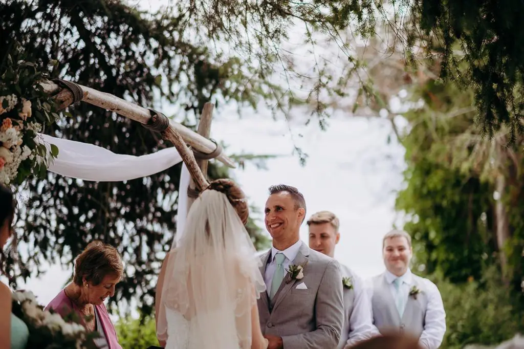 groom smiles as he says his vows to his bride in Gibsons BC