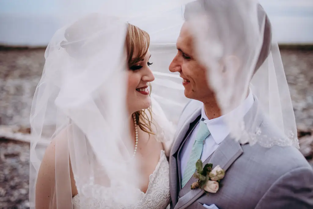 bride and groom under the brides veil