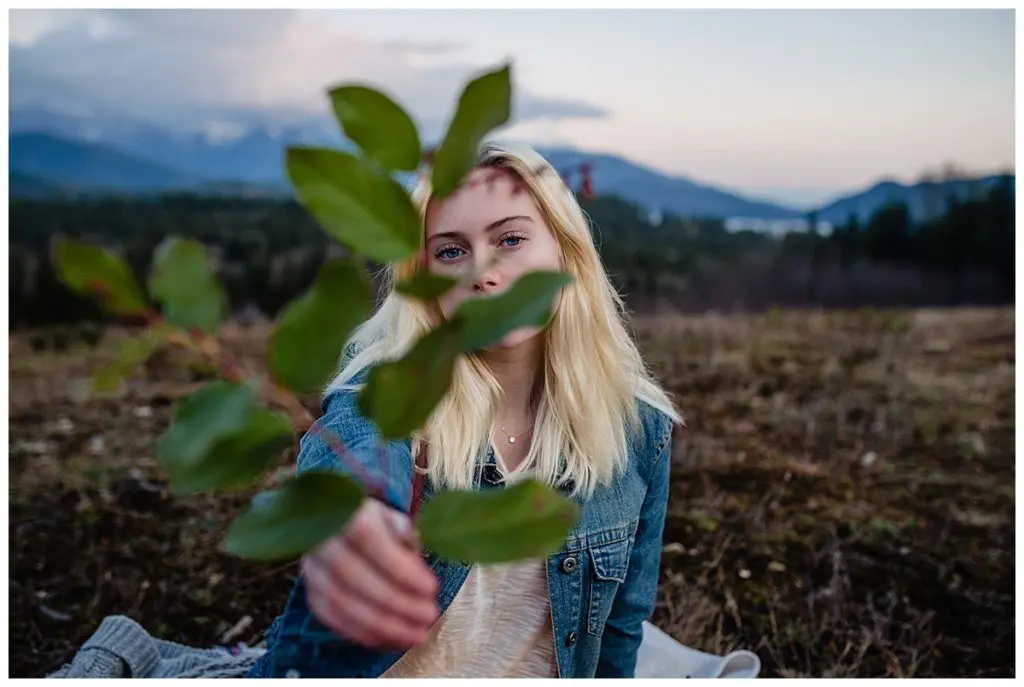 girl holds a Branch in front of her in the mountains Sunshine Coast BC