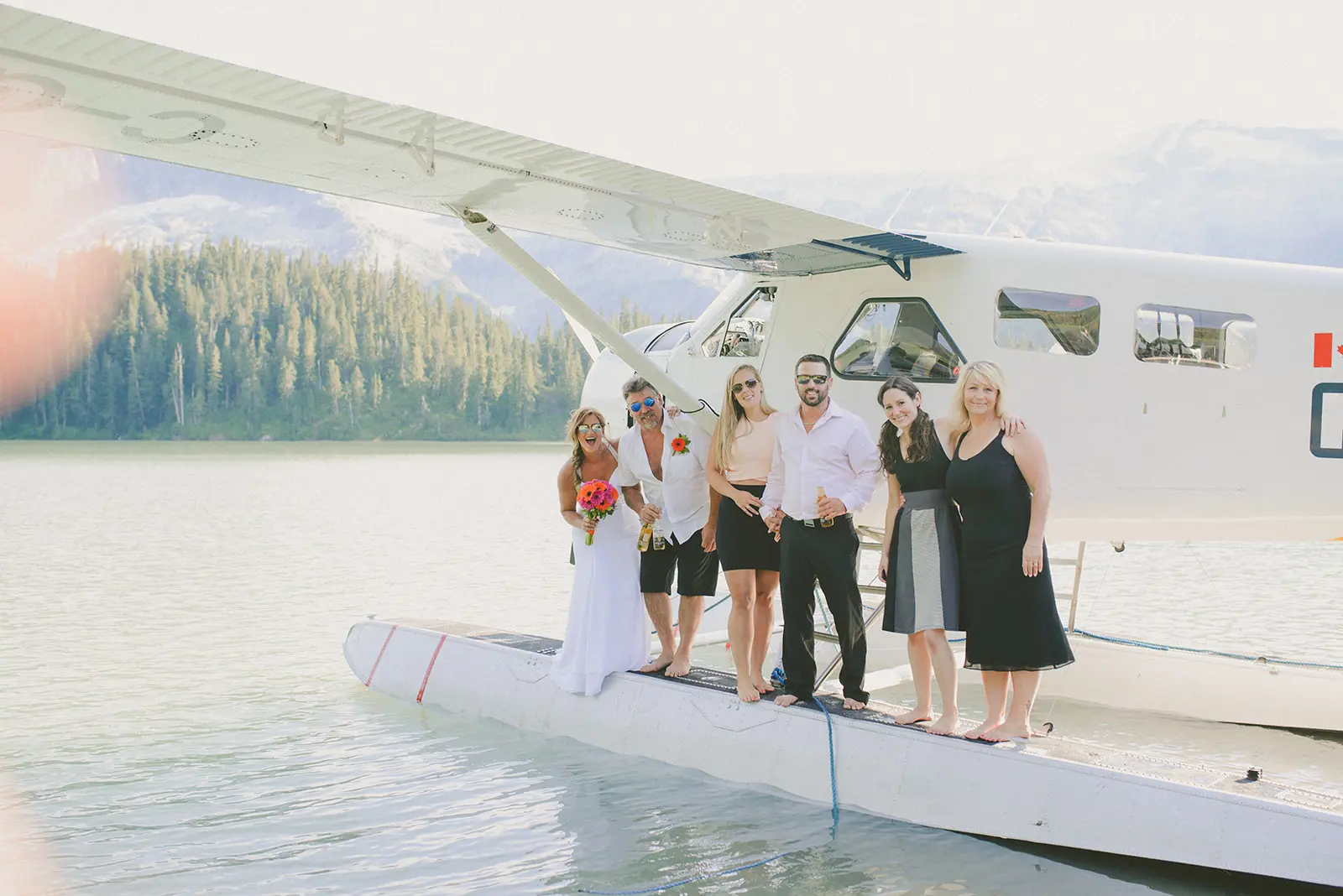 friends stand on the wing of a plane in phantom lake during an Adventure Elopement in British Columbia on the Sunshine Coast