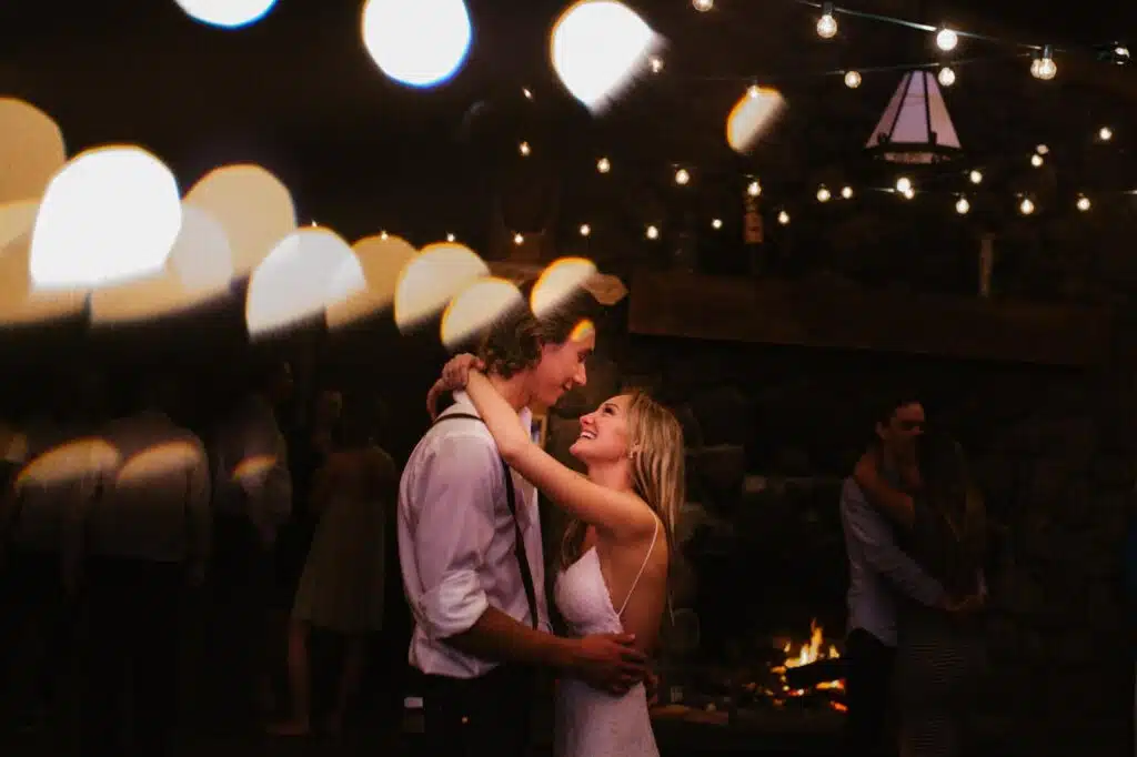 a sunshine coast bc wedding photographed by fresh air photography with a bride and groom dancing in a dark outdoor venue with lights strung up everywhere. 